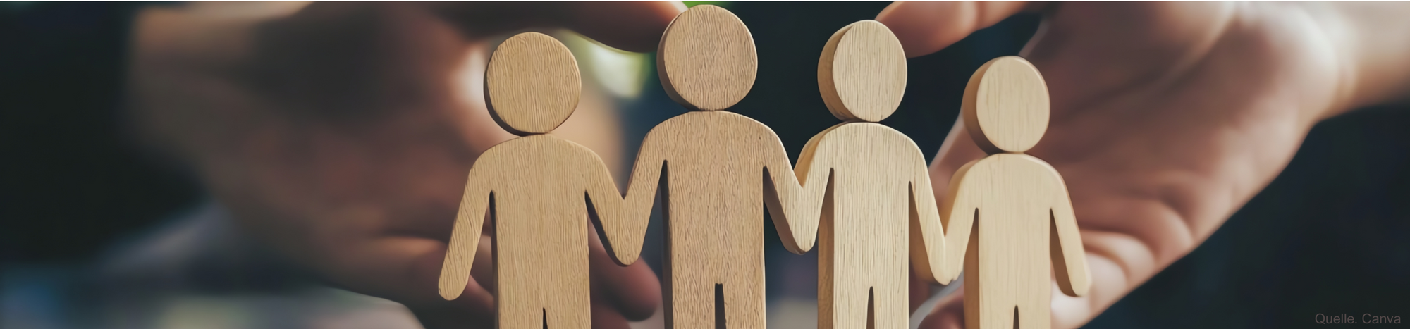 Image of three wooden figures, supported by two hands