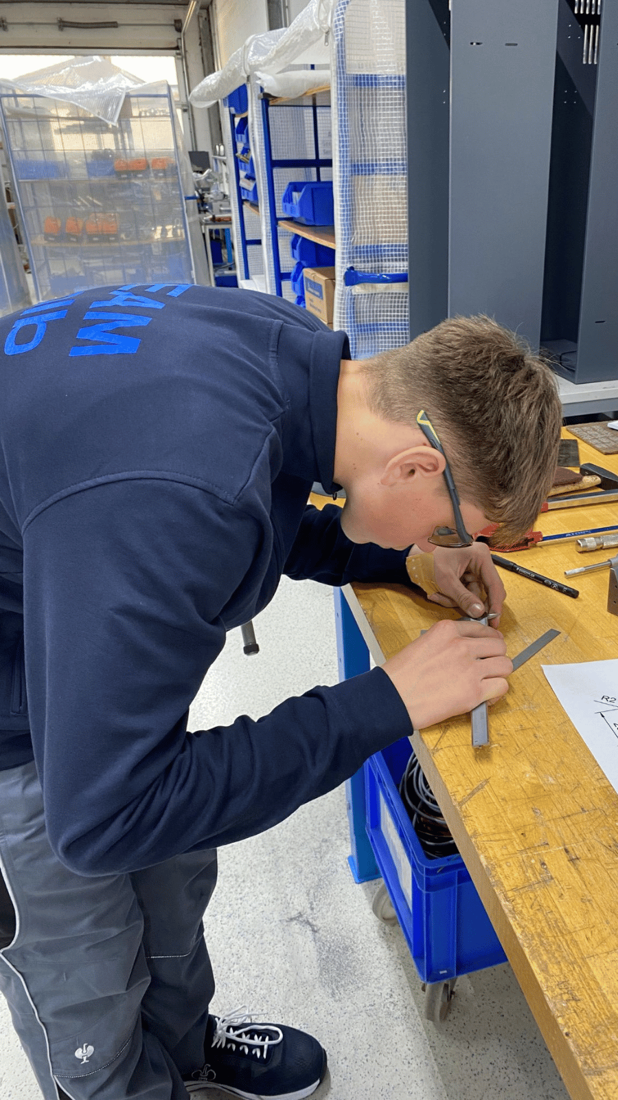 Ben working in the mechanics department, measuring.